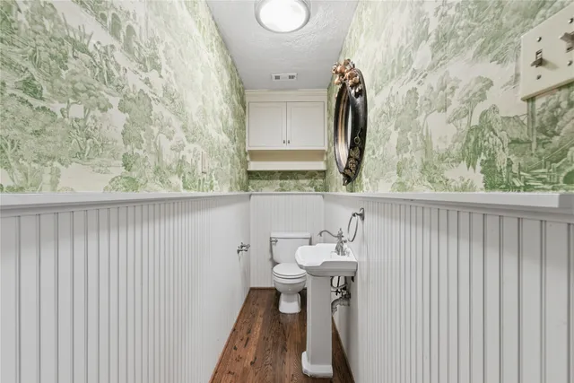 a bathroom with a sink and mirror with toilet