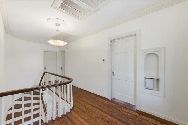 a view of a hallway with wooden floor and staircase