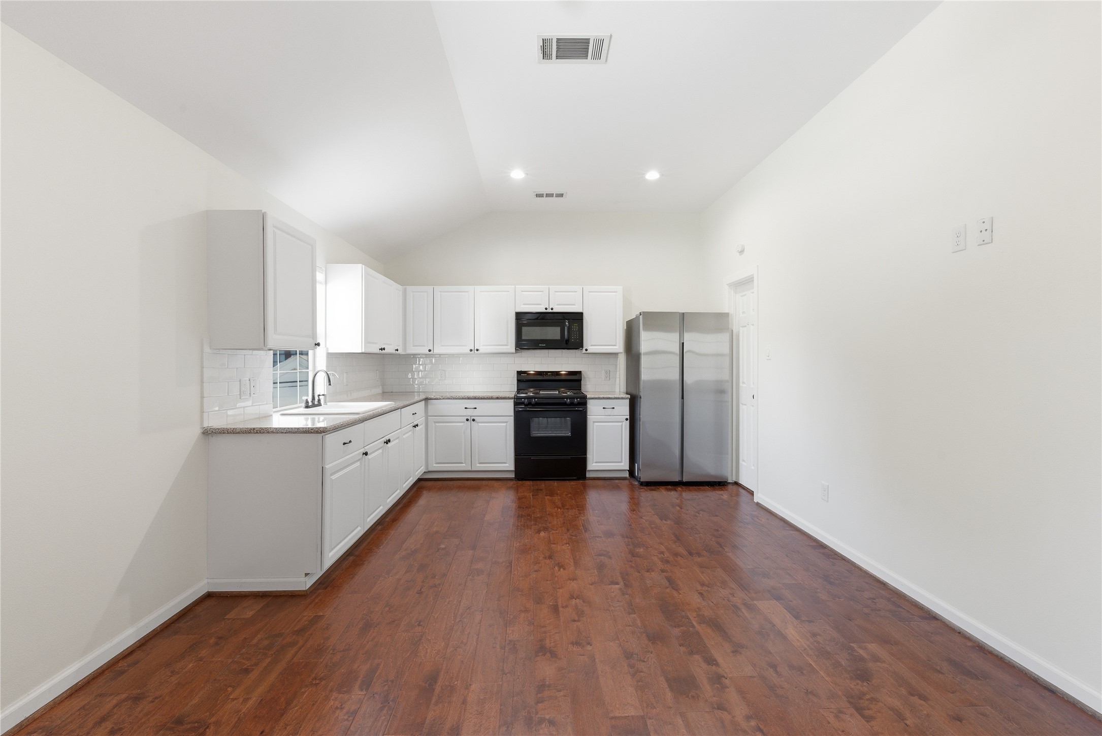 6666 Fairfield Street Houston, TX 77023 - Photo 40 of 48 a kitchen with a refrigerator and white cabinets