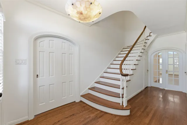 wooden floor in an entryway with a chandelier