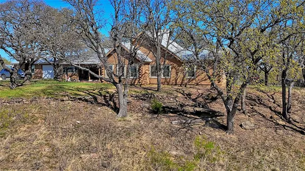 a view of grassy field with benches and trees all around