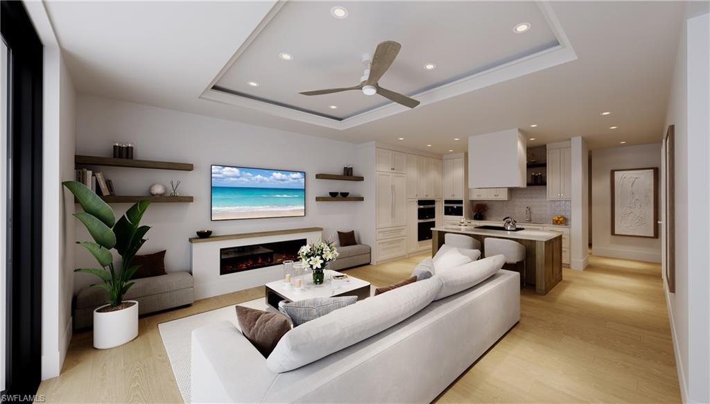 a living room with fireplace furniture and a kitchen view