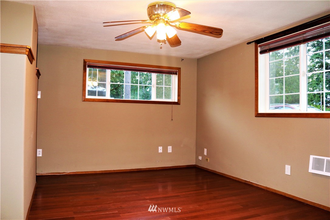 8325 Custer Road Southwest Lakewood, WA 98499 - Photo 16 of 20 a view of an empty room with wooden floor and a window
