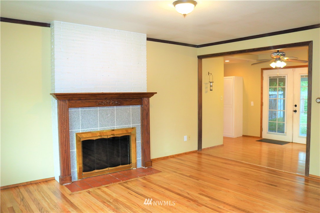 8325 Custer Road Southwest Lakewood, WA 98499 - Photo 6 of 20 a view of an empty room with wooden floor and a fireplace