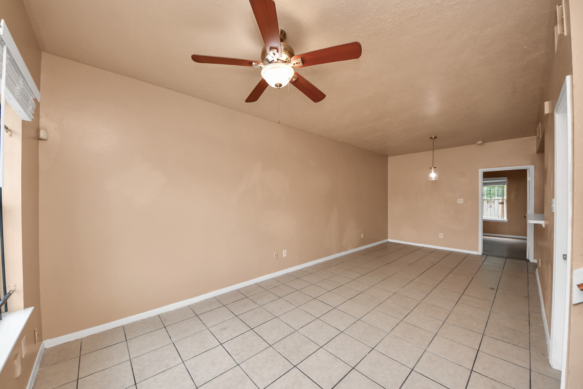 8130 Jutland Road Houston, TX 77033 - Photo 12 of 47 an empty room with white walls and ceiling fan