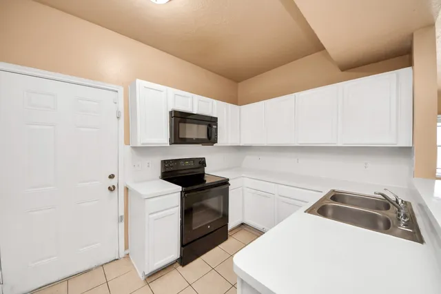 a kitchen with a sink a stove top oven and white kitchen