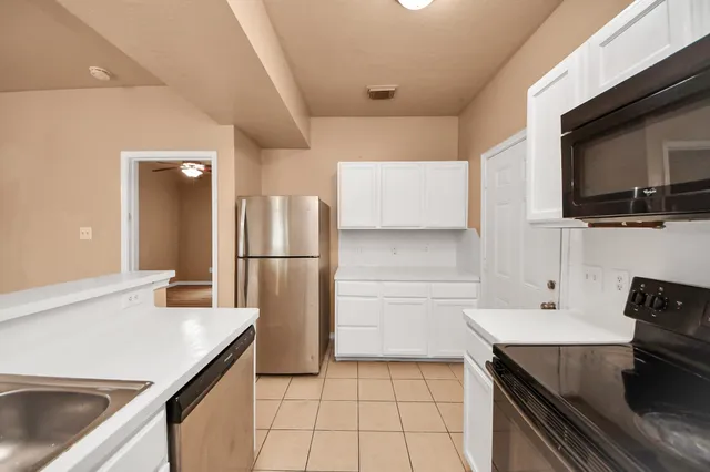 a kitchen that has a sink cabinets counter space and appliances