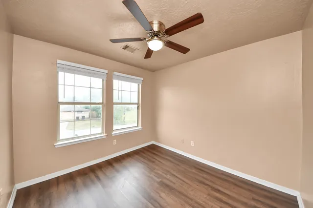 a view of an empty room with wooden floor