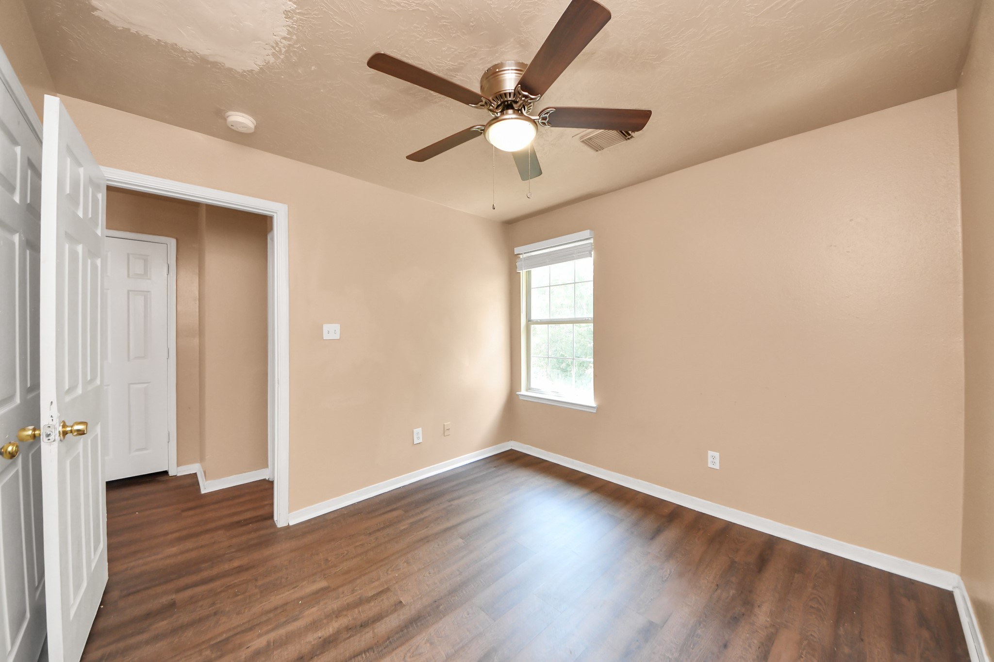 8130 Jutland Road Houston, TX 77033 - Photo 40 of 47 an empty room with wooden floor fan and windows