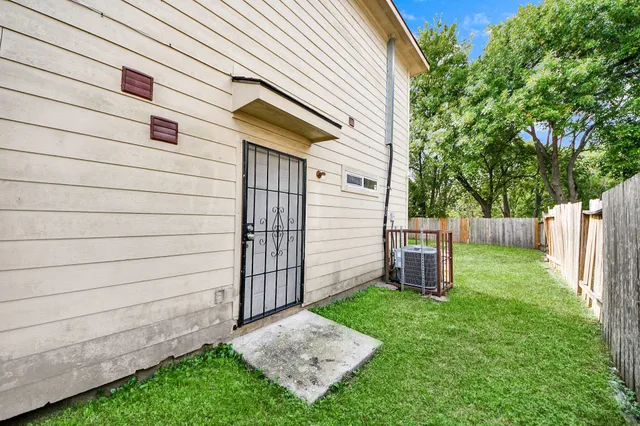 a view of a backyard with a trees and wooden fence
