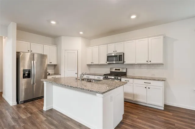 a kitchen with stainless steel appliances granite countertop a refrigerator and a sink