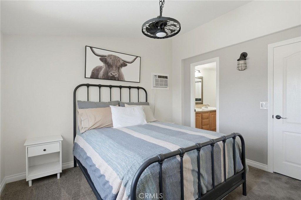 40100 Owl Valley Road Temecula, CA 92592 - Photo 18 of 44 a bedroom with a bed and a chandelier