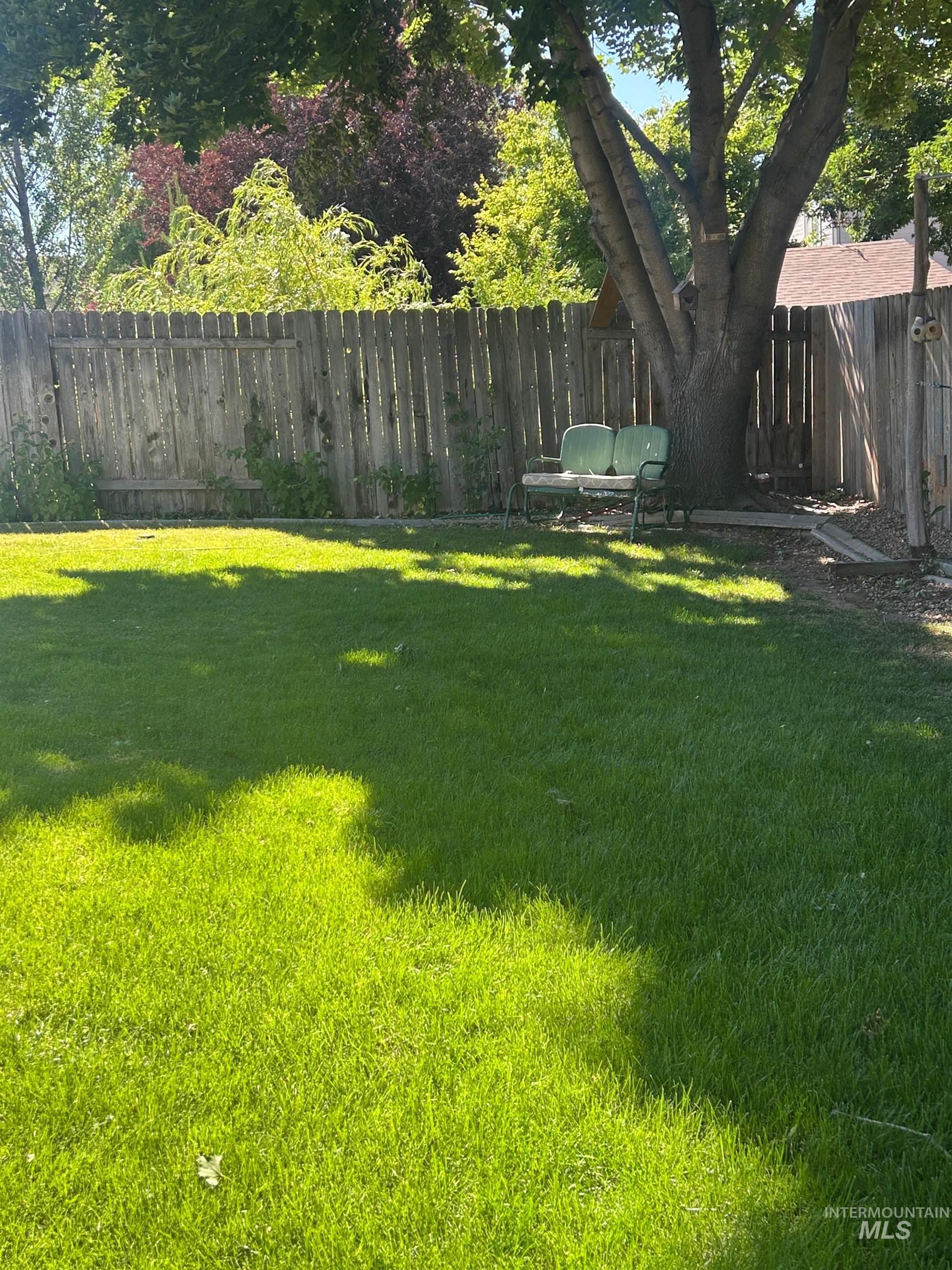 1444 East Doberman Street Meridian, ID 83642 - Photo 28 of 31 Expansive backyard featuring a lush lawn, mature trees, and privacy fencing