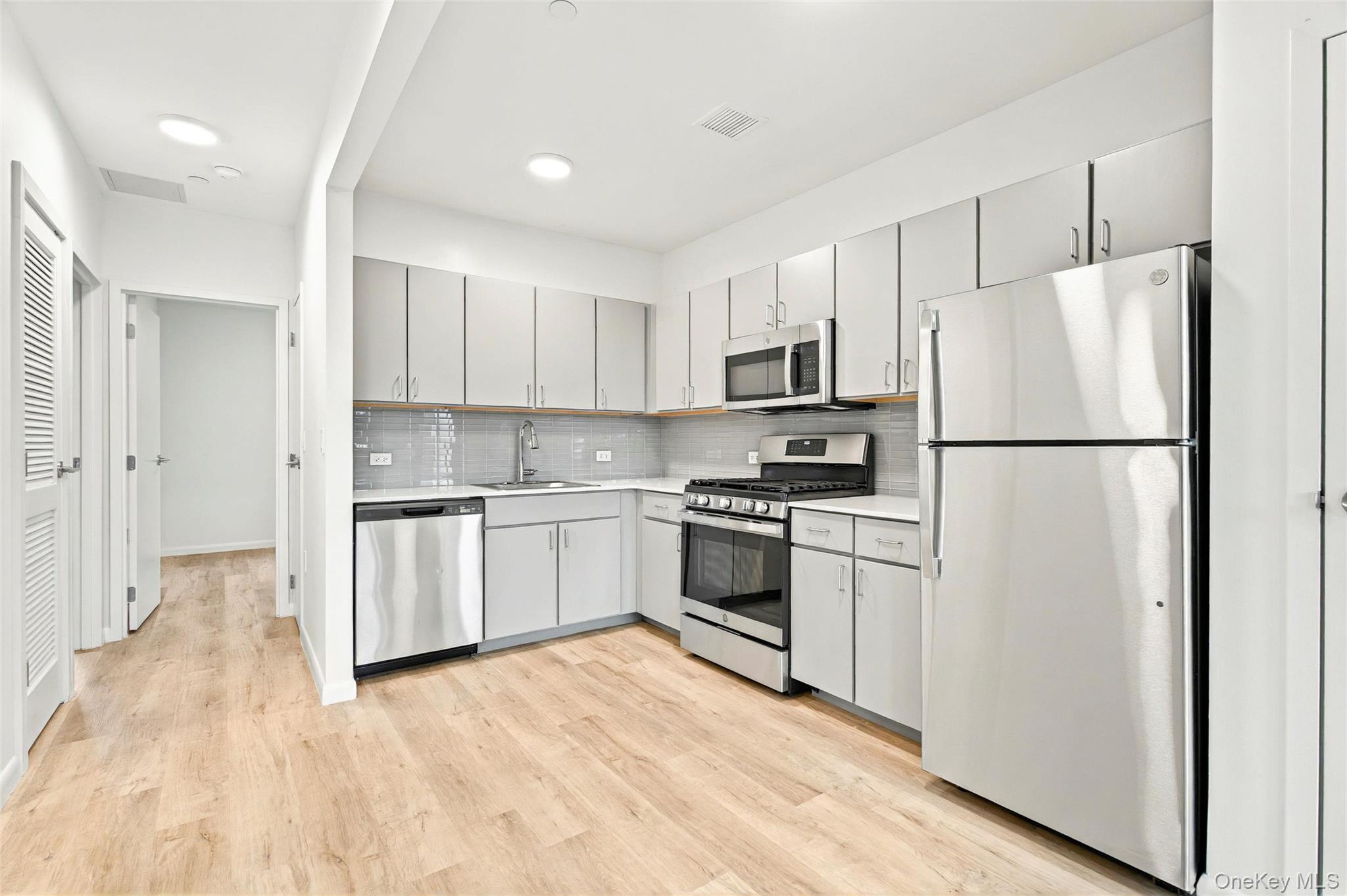 1715 A Lacombe Avenue, Unit 4A Bronx, NY 10473 - Photo 18 of 29 a kitchen with white cabinets and white appliances