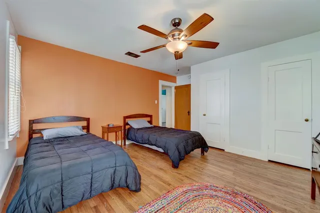 a bedroom with two beds and a large window