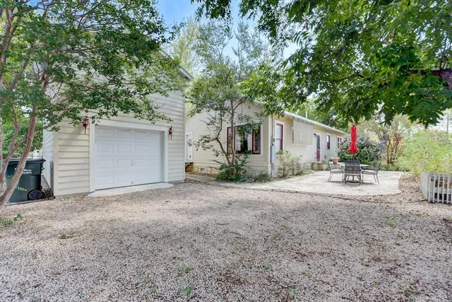 a view of a house with backyard and a tree