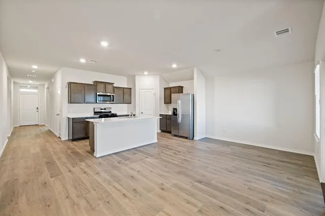 a kitchen with stainless steel appliances a refrigerator and a stove top oven