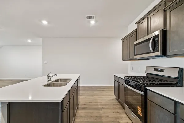 a kitchen with a sink stove and refrigerator
