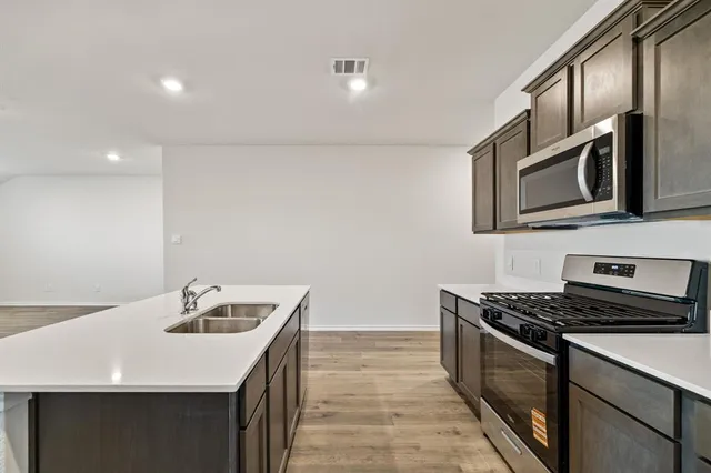 a kitchen with a sink stove and refrigerator