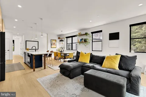a living room with furniture and view of kitchen