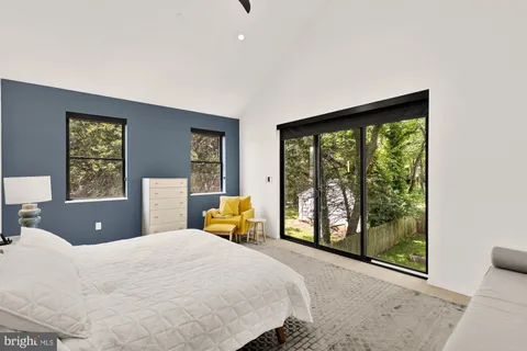 a bedroom with a bed and large windows