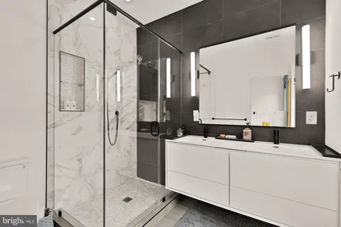a bathroom with a double vanity sink mirror and shower