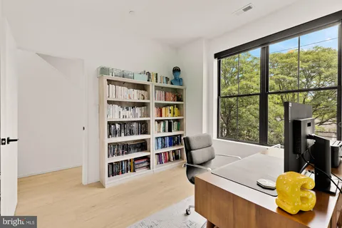 a living room with furniture and a book shelf