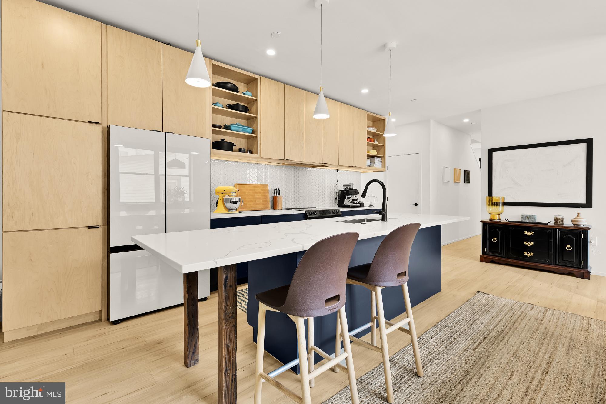4020 35th Street, Unit B Mount Rainier, MD 20712 - Photo 8 of 42 a kitchen with stainless steel appliances a sink a stove a refrigerator a dining table and chairs with wooden floor
