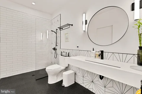 a bathroom with a sink a toilet and a mirror