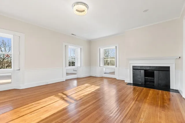 wooden floor fireplace and windows in an empty room