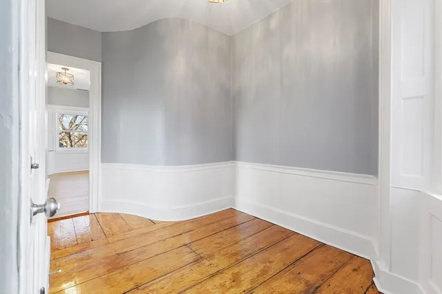 a view of a bedroom with wooden floor and bathroom