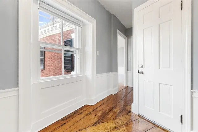 a view of a hallway with wooden floor and entryway