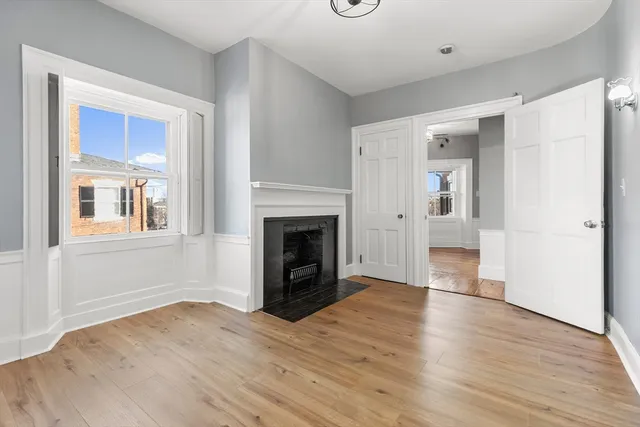 a view of a livingroom with wooden floor and a kitchen