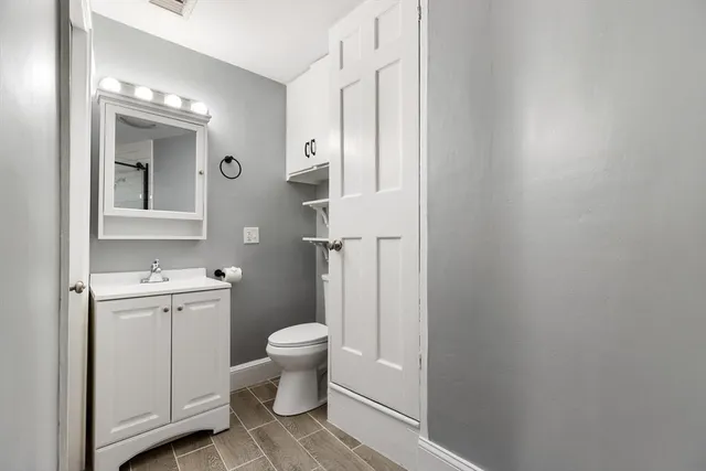 a bathroom with a toilet sink and mirror