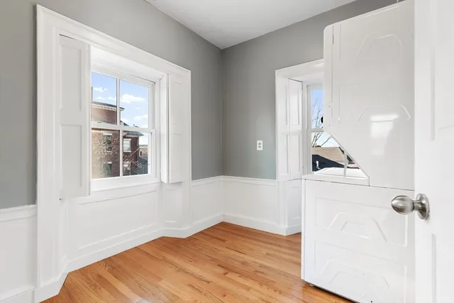 a view of a bedroom with wooden floor and cabinet