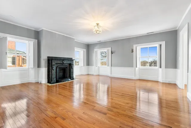 a view of empty room with wooden floor and fireplace