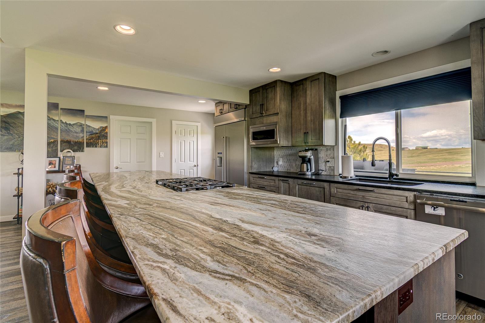 4531 East Best Road Larkspur, CO 80118 - Photo 4 of 49 a room with stainless steel appliances kitchen island granite countertop a sink and cabinets
