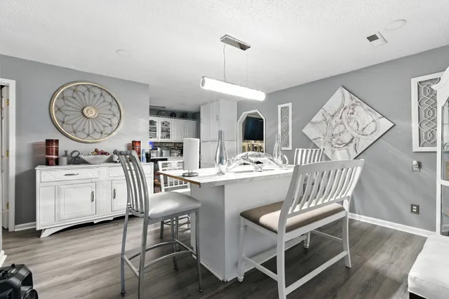 a view of a dining room with furniture clock and wooden floor
