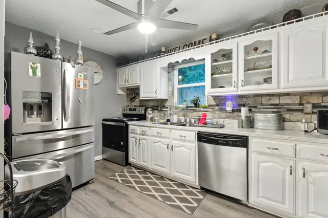 a kitchen with a refrigerator and white cabinets