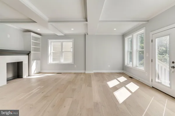 an empty room with windows and fireplace