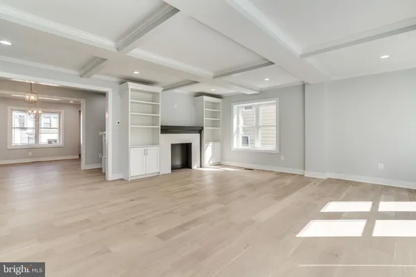 an empty room with windows and fireplace