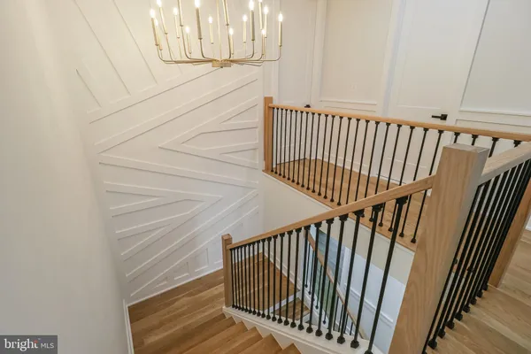 a view of staircase with railing and white walls