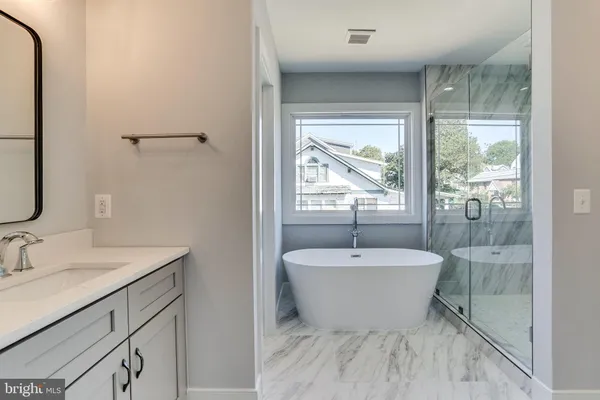 a spacious bathroom with a bathtub sink and mirror