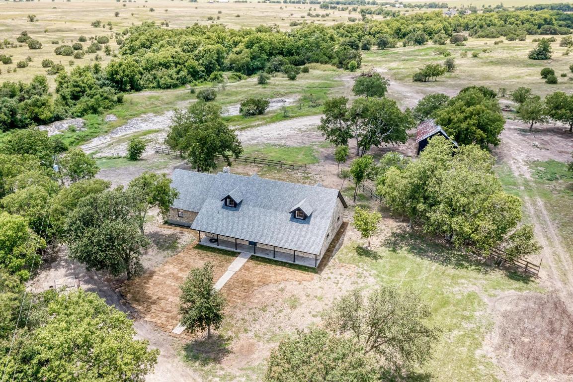 an aerial view of a house with a yard and lake view