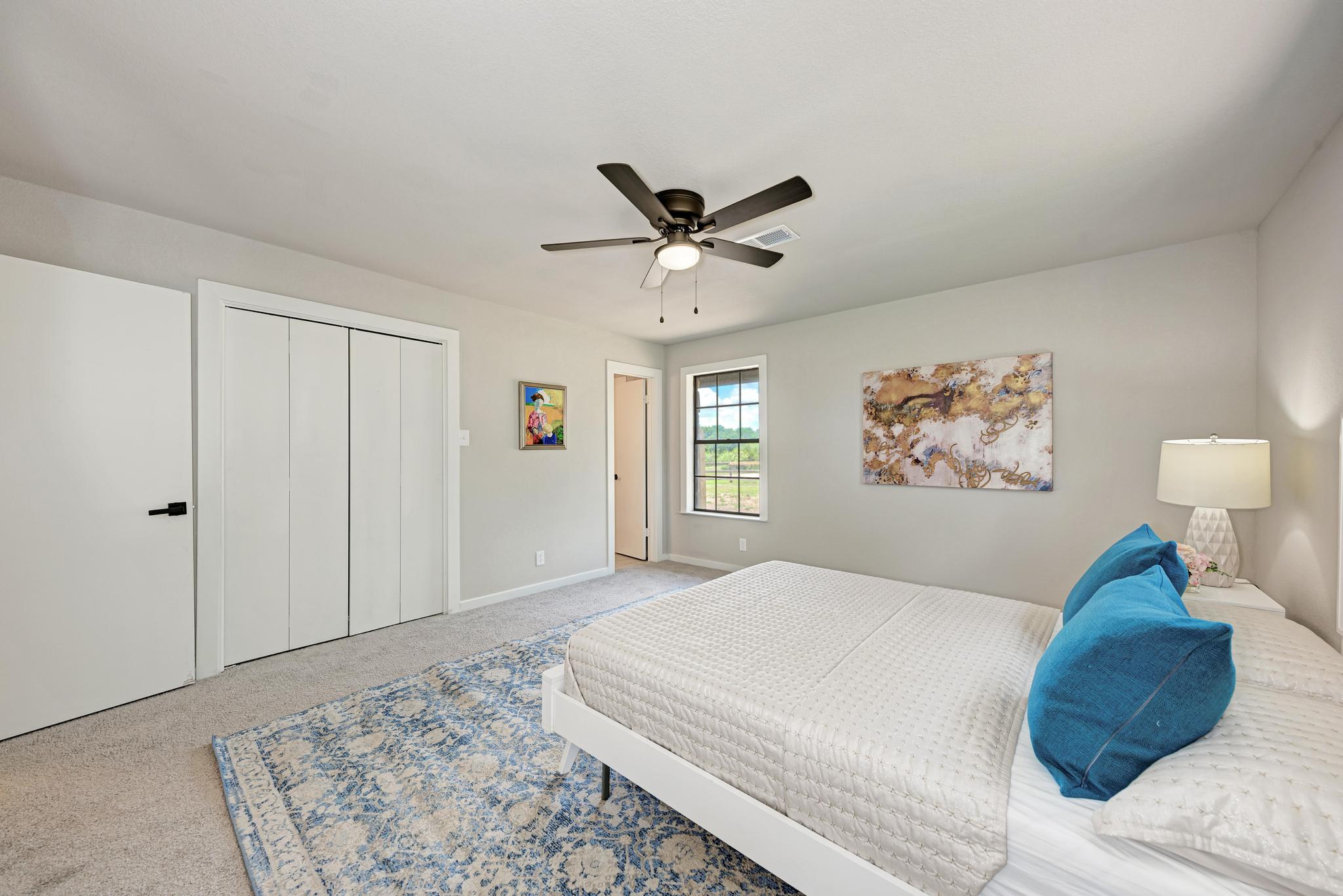 2365 Hackberry Road Salado, TX 76571 - Photo 24 of 40 a bedroom with a large bed and a chandelier