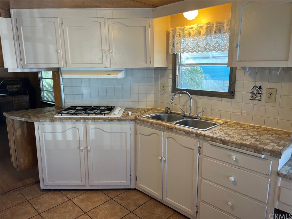 13645 5th Street, Unit 35 Yucaipa, CA 92399 - Photo 8 of 22 a kitchen with white cabinets and window