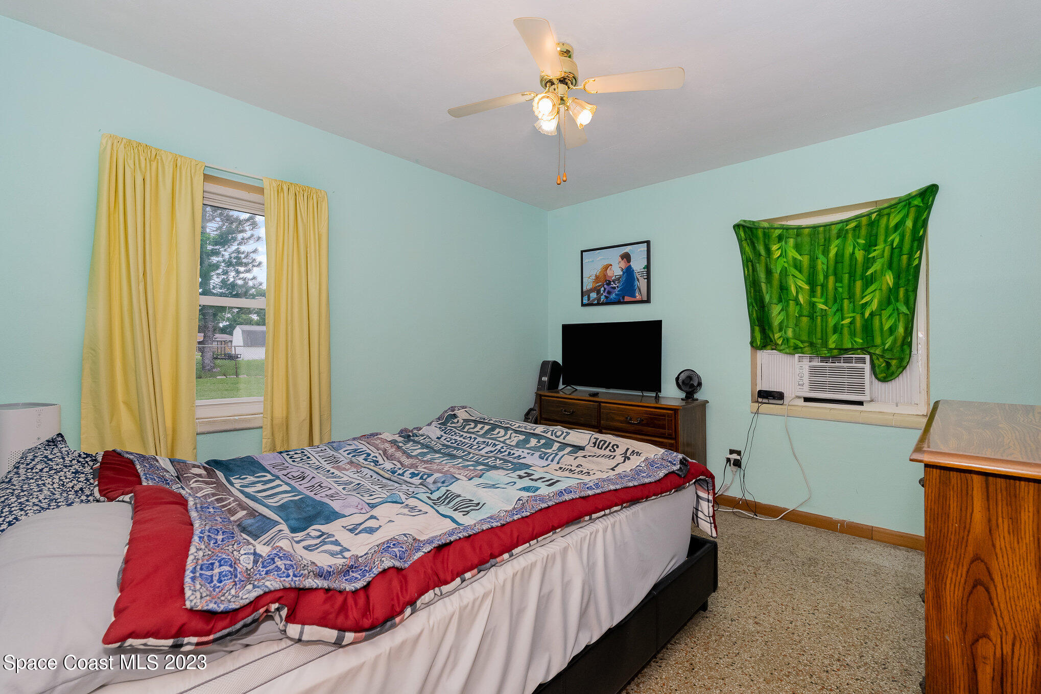 109 Cherry Street Melbourne, FL 32901 - Photo 7 of 31 a bedroom with a bed and a chandelier