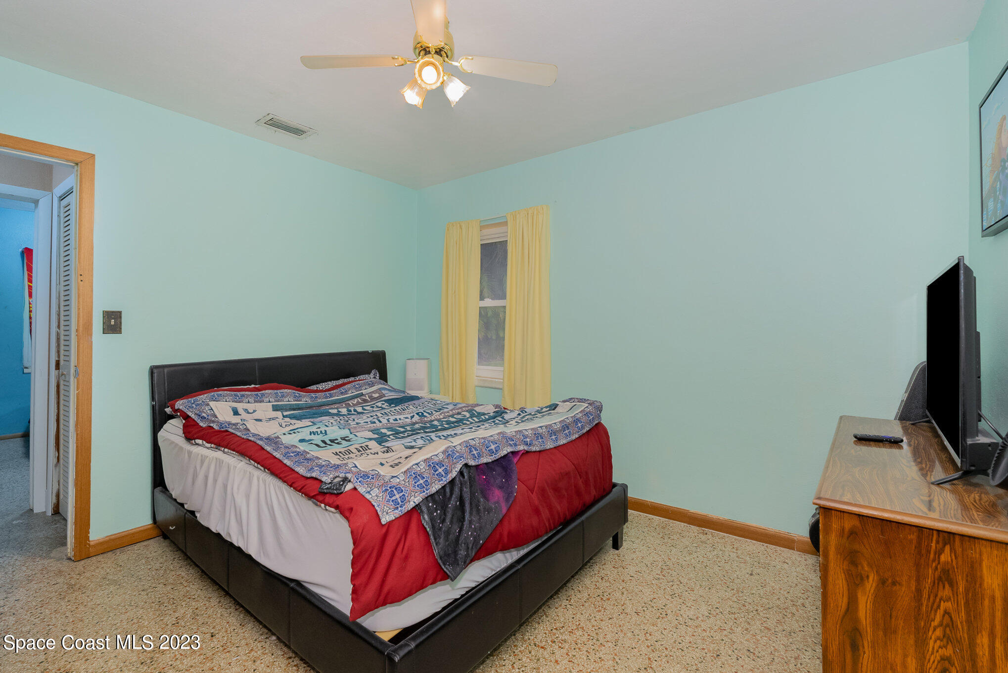 109 Cherry Street Melbourne, FL 32901 - Photo 8 of 31 a bedroom with a bed and a flat screen tv