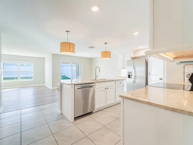 a view of a kitchen with wooden floor and electronic appliances