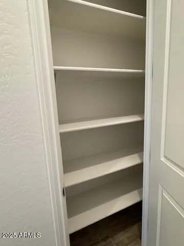a view of walk in closet with empty racks